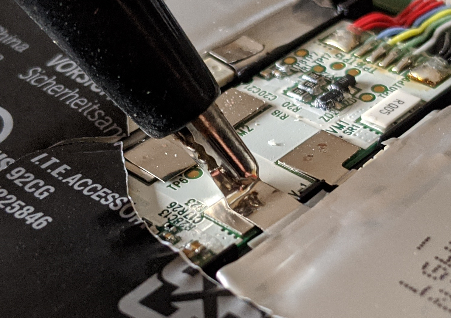 Screwdriver bending up a cell tab on the battery protection board