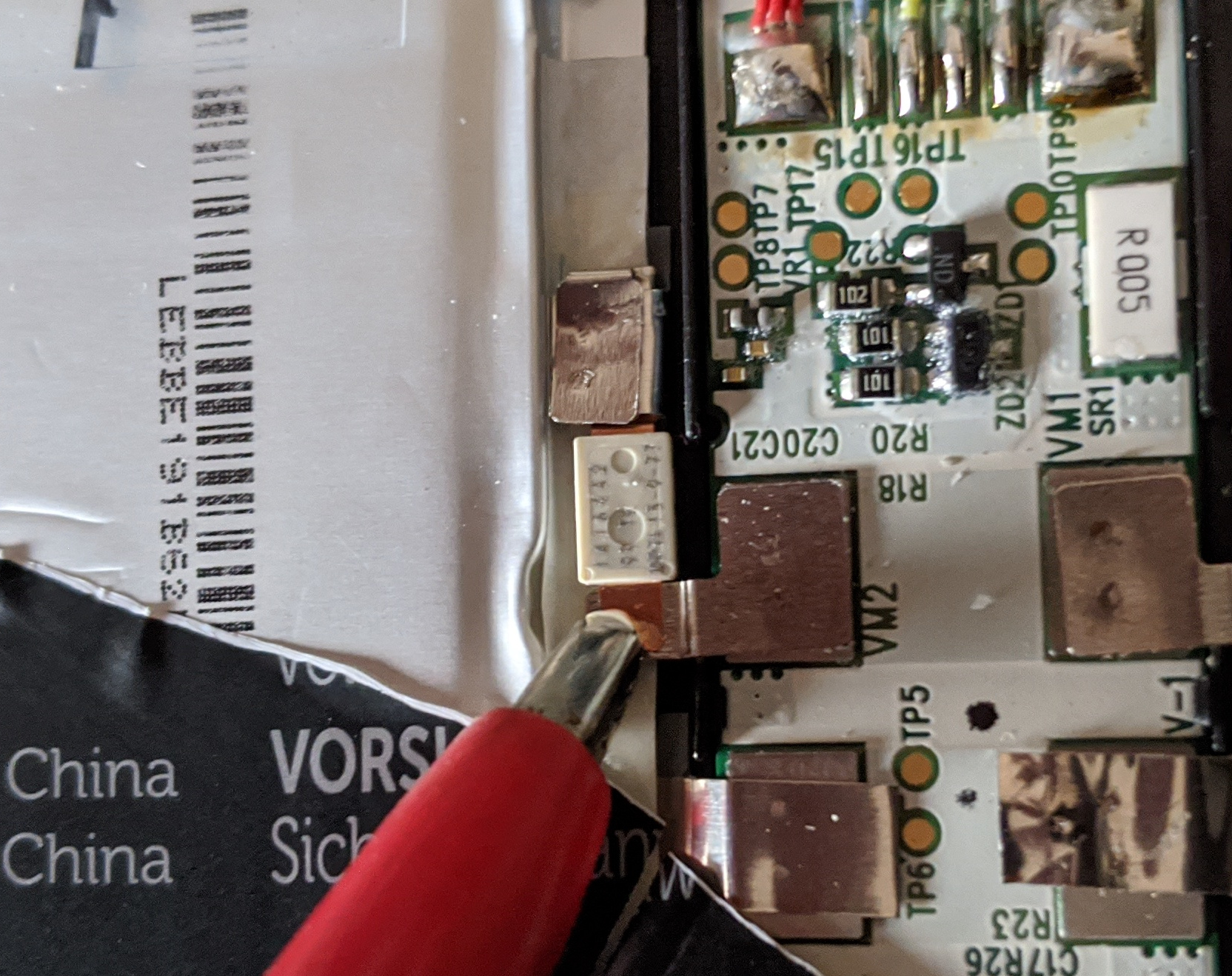 Red crocodile clip attached to the edge of a cell tab on the battery board