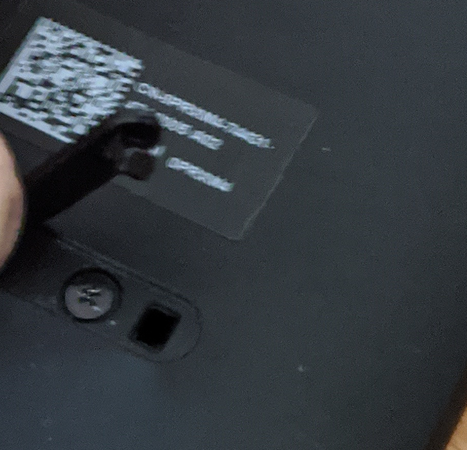 Screwdriver on one of the screws under the rubber strip on the keyboard base